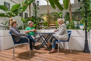 Sitzbereich mit Gästen zwischen üppigen exotischen Pflanzen
